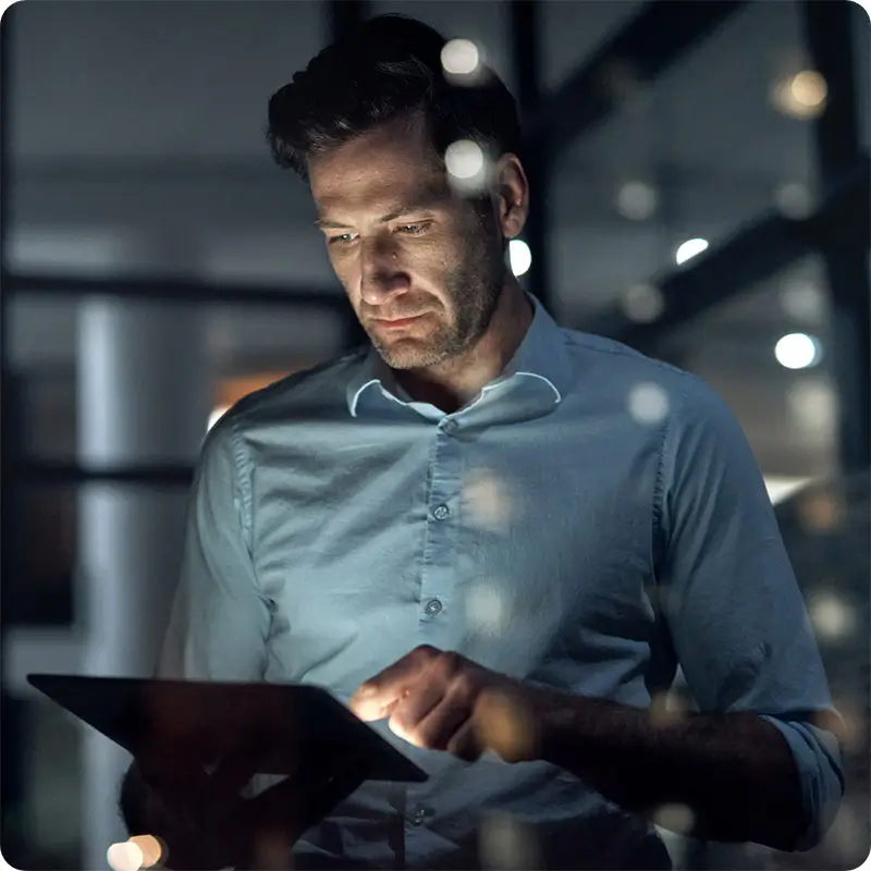 Businessman looking at tablet in office at night
